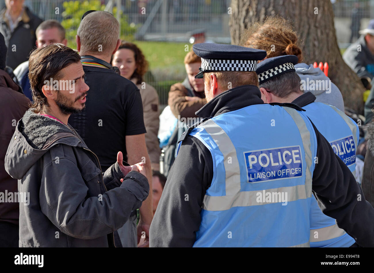 Londres, Royaume-Uni. 22 octobre, 2014. Occupy London protestataire reste sur le socle de la statue de Winston Churchill à la place du Parlement que la police commence à arrêter des gens qui jettent de la nourriture et de l'eau pour lui. Les agents de liaison de parler à un manifestant Banque D'Images