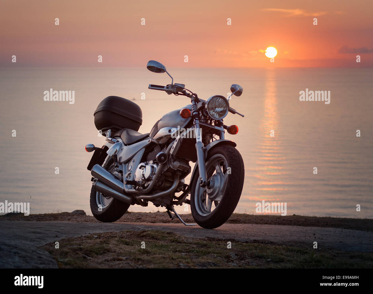 Custom moto dans un coucher du soleil avec la mer en arrière-plan Banque D'Images