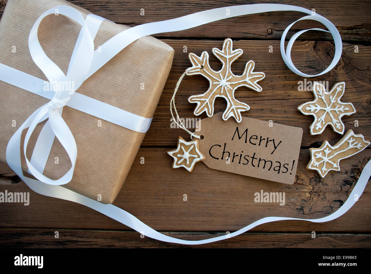 Joyeux Noël Bonjour sur Tag naturel sur fond de bois décoré avec une boîte cadeau et pain d'Épices Cookies, Noël Retour Banque D'Images