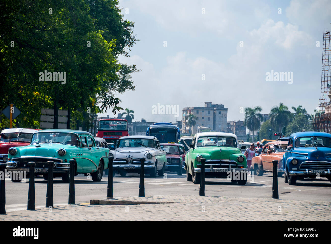 Vintage vieilles voitures américaines utilisées comme taxis représentent la majorité du trafic passant Parque Central sur le Prado à La Havane à Cuba. Banque D'Images