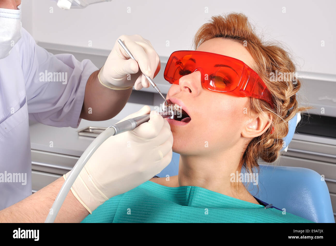 Jeune fille avec des lunettes rouge chaise de bureau de dentiste en Banque D'Images