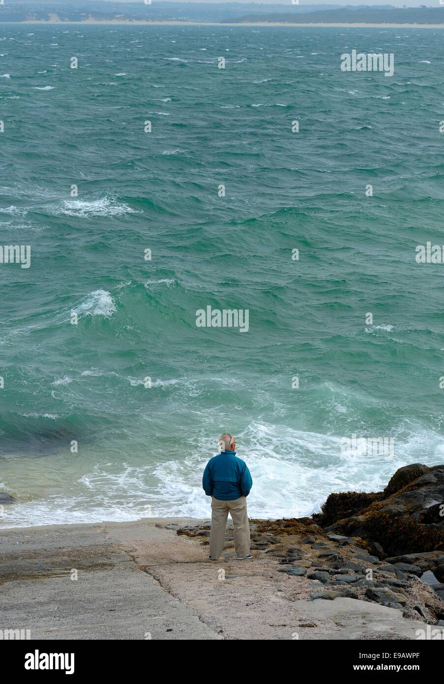 Un homme regardant dans une mer agitée St Ives Cornwall England uk Banque D'Images