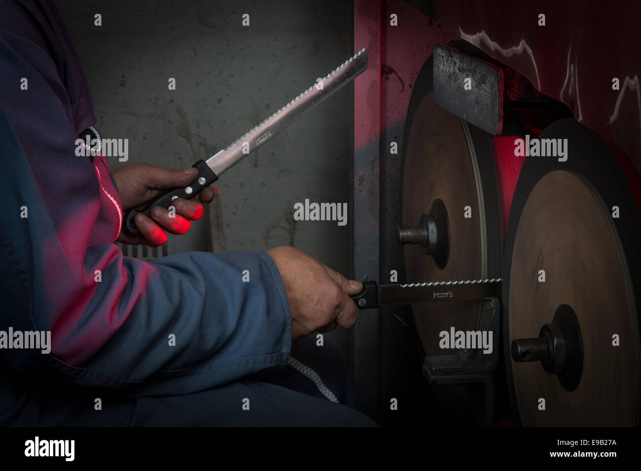 Une étape dans la fabrication d'un couteau dans une coutellerie de Thiers (France). Knifegrinder - aiguiseur de couteau - Couteau - hachoir-broyeur Banque D'Images