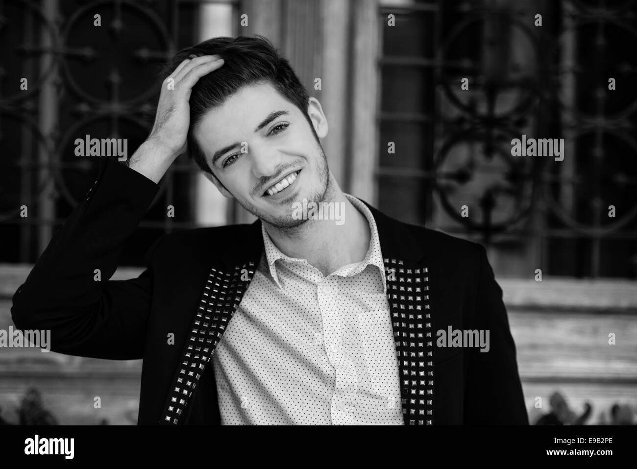 Portrait noir et blanc d'un beau jeune homme souriant Banque D'Images