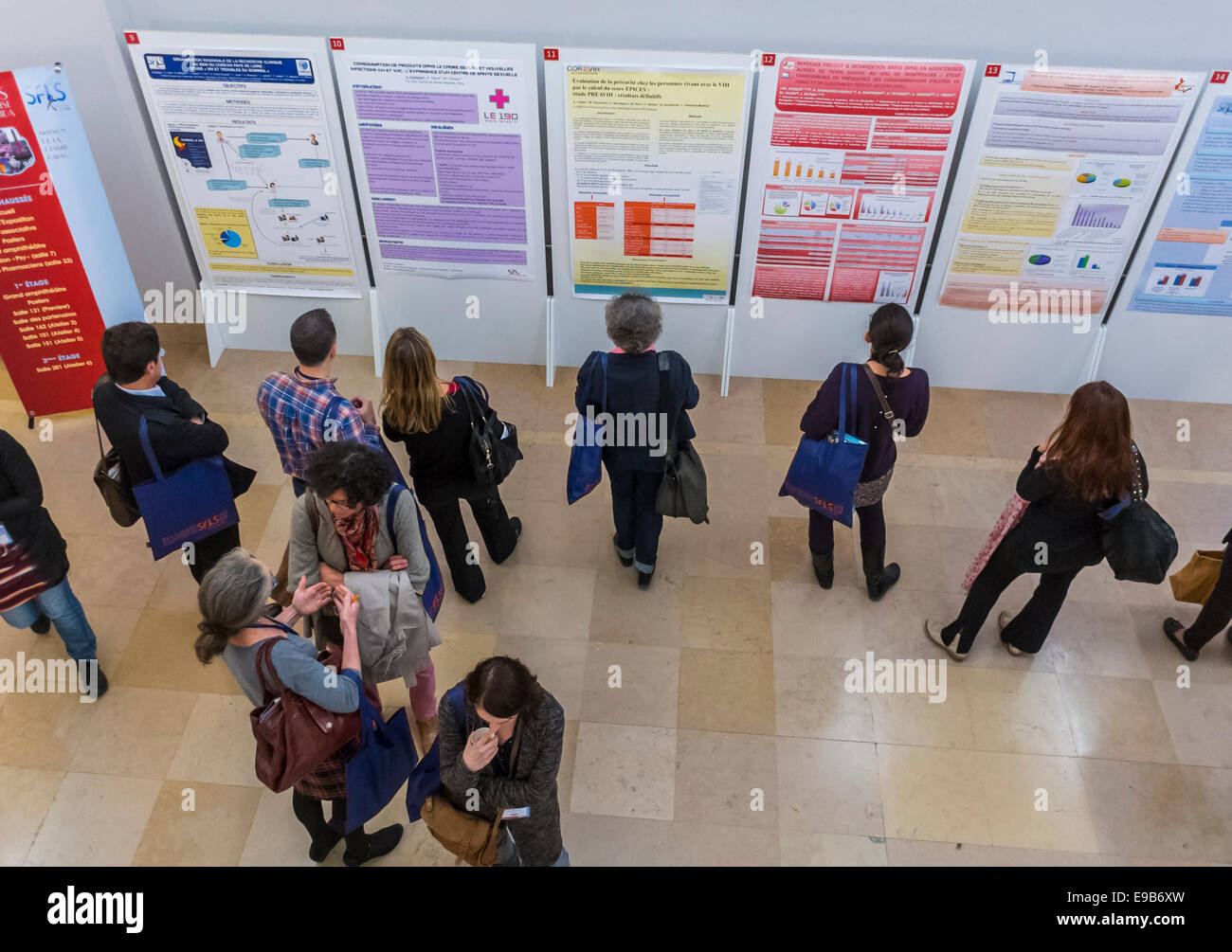 Paris, France. High angle, Medical Trade Show, Meeting of SFLS, Société française de lutte contre le SIDA, N.G. O's, et Drug Companies. Les femmes lisant des affiches de recherche sur le mur dans le hall, partage des scientifiques, recherche sur les aides au vih, Paris science Banque D'Images