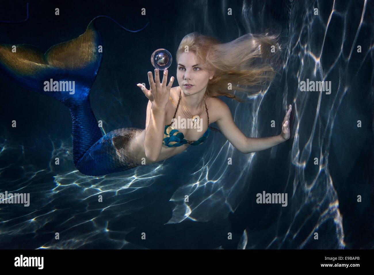Sirène blonde jouant avec une bulle dans une piscine à Virginia Beach, Virginie Banque D'Images