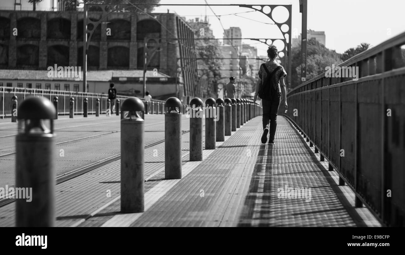 Noir et blanc photo de Femme avec sac à dos marche sur bridge Banque D'Images