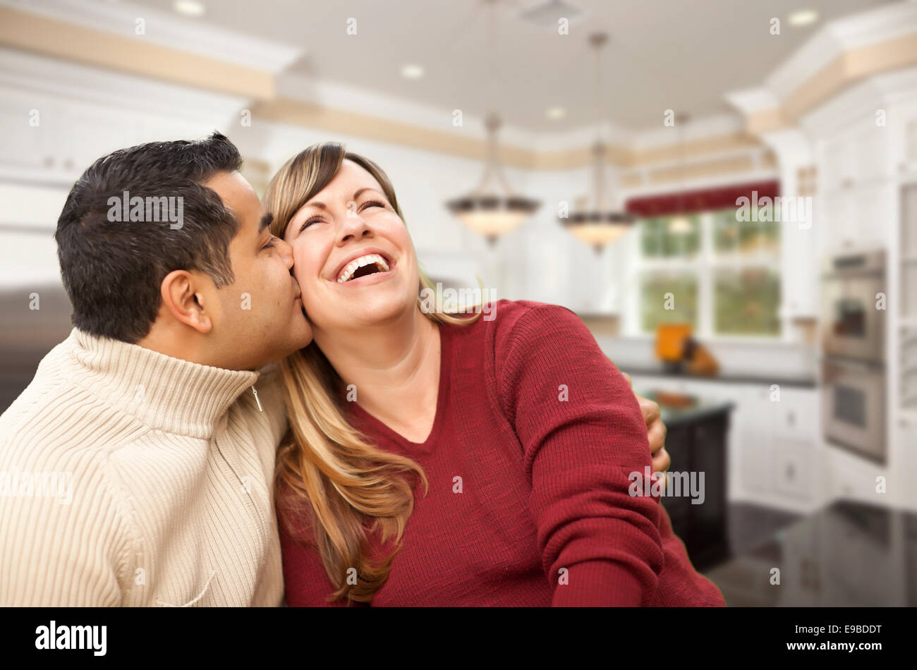 Happy Mixed Race Couple à l'intérieur belle cuisine sur mesure. Banque D'Images