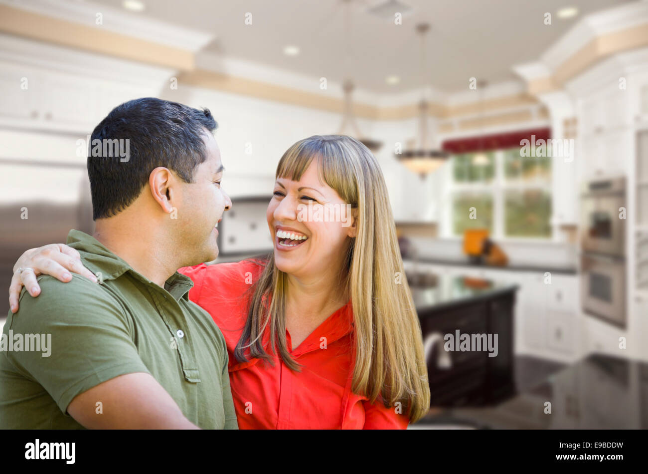 Mixed Race couple heureux à l'intérieur belle cuisine sur mesure. Banque D'Images
