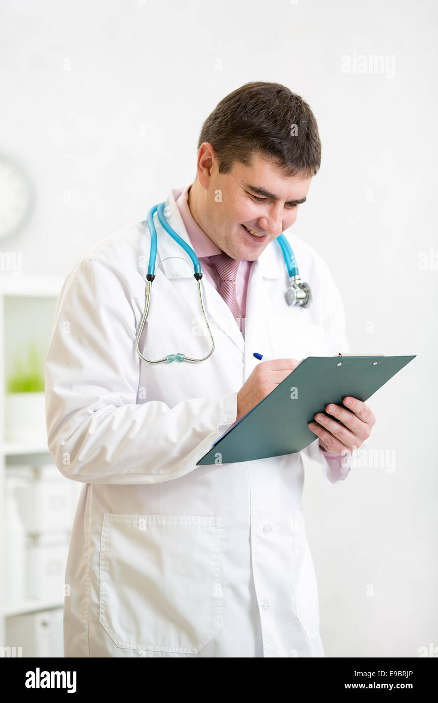 Portrait of smiling male doctor with clipboard at office Banque D'Images