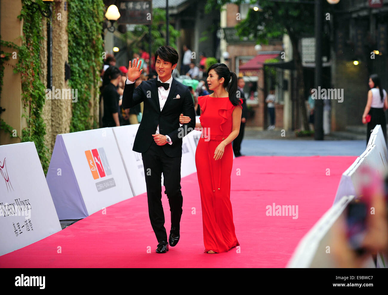 Haikou, province de Hainan en Chine. 24 Oct, 2014. Acteur brunéiens chun Wu (L) vagues à l'auditoire au tapis rouge de la cérémonie 2014 de la célébrité dans le monde du tournoi de golf Pro-Am à Haikou, capitale de la province de Hainan en Chine du sud, le 24 octobre 2014. Credit : Guo Cheng/Xinhua/Alamy Live News Banque D'Images