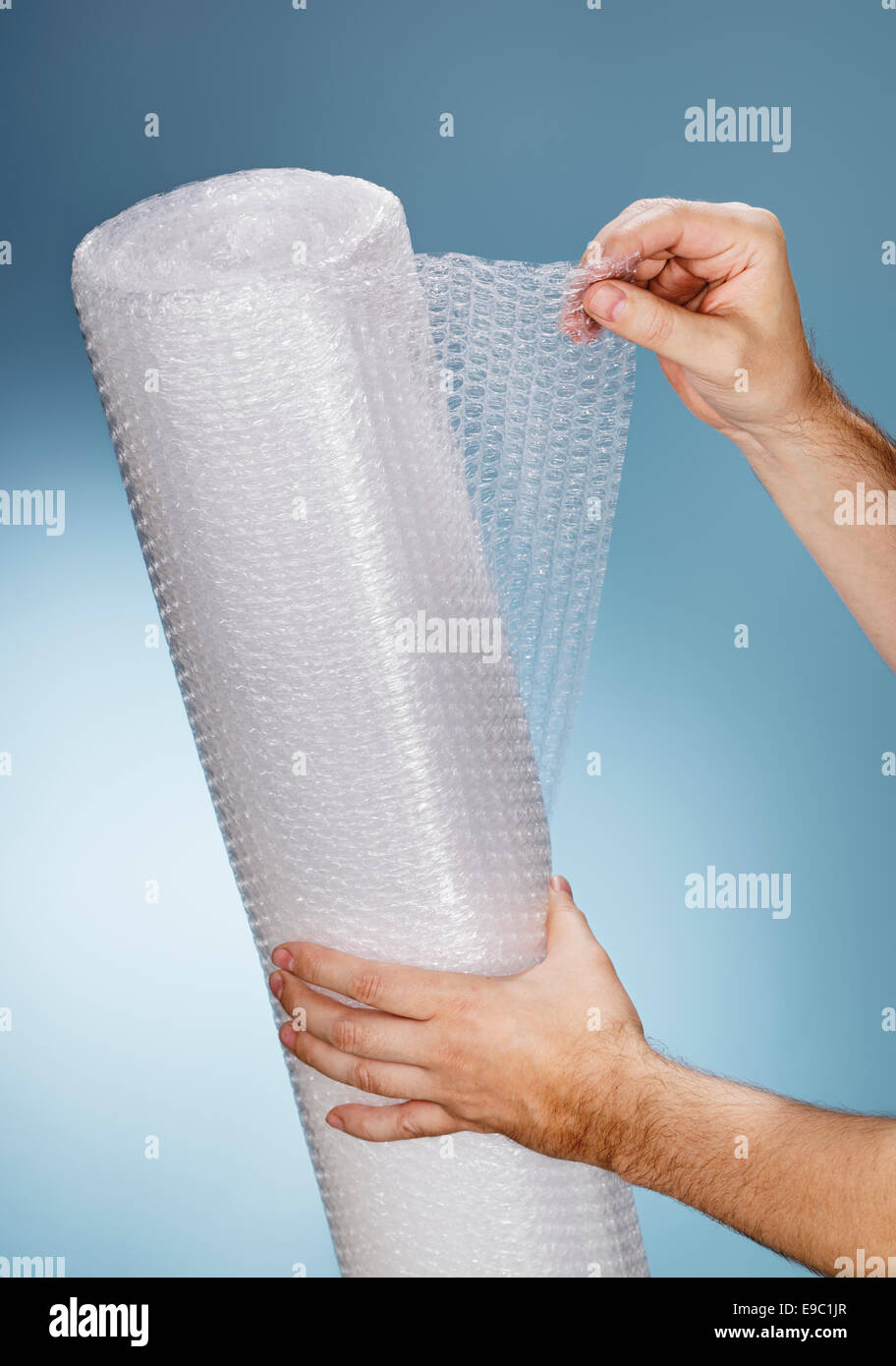 Homme tenant un rouleau de plastique à bulles. Banque D'Images