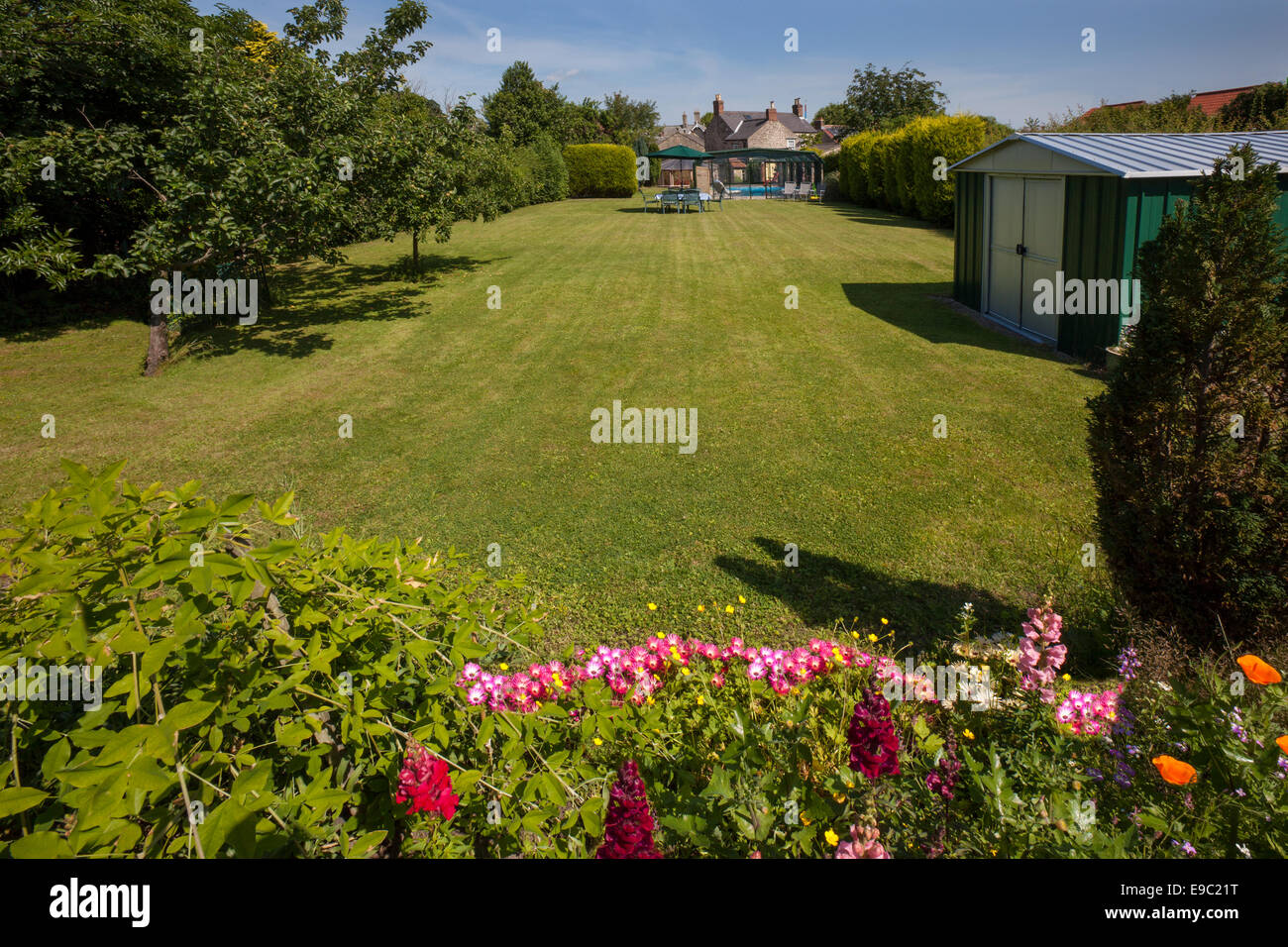 Un grand jardin et pelouse à l'arrière d'une maison dans un village du Yorkshire, Angleterre. Banque D'Images