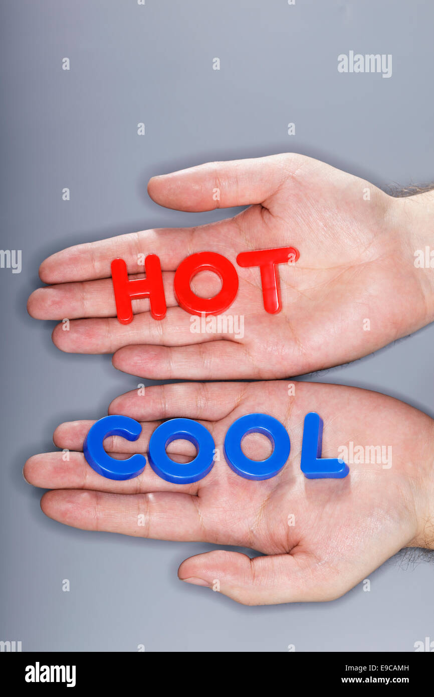 Man holding plastic letters spelling HOT and cool dans ses mains. Banque D'Images