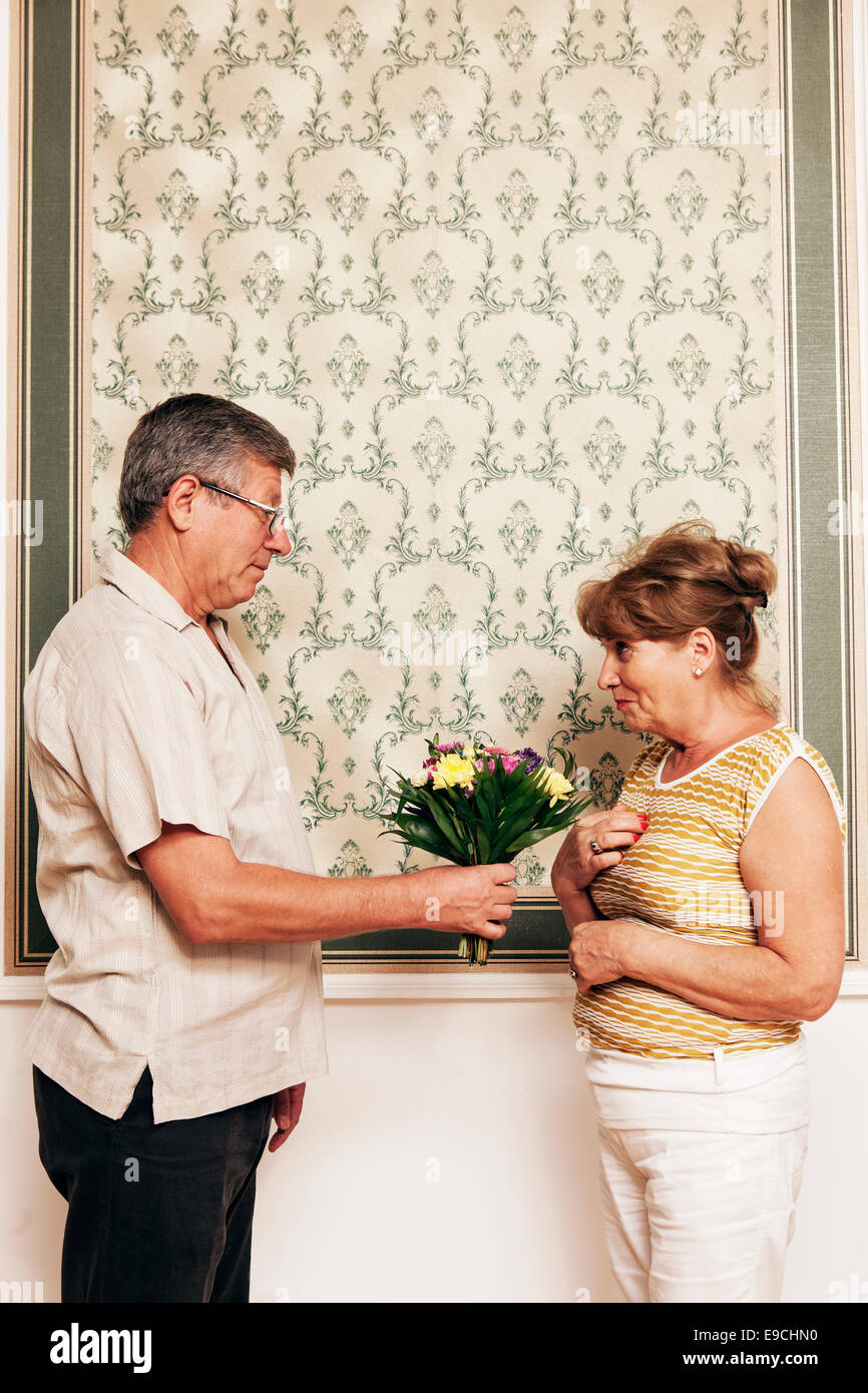 Homme plus âgé donnant femme bouquet de fleurs Banque D'Images