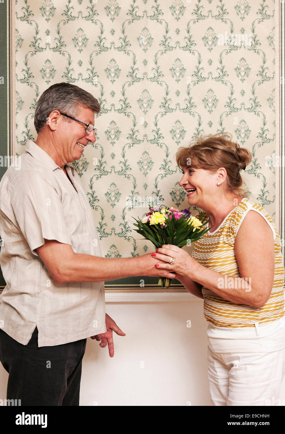 Homme plus âgé donnant femme bouquet de fleurs Banque D'Images