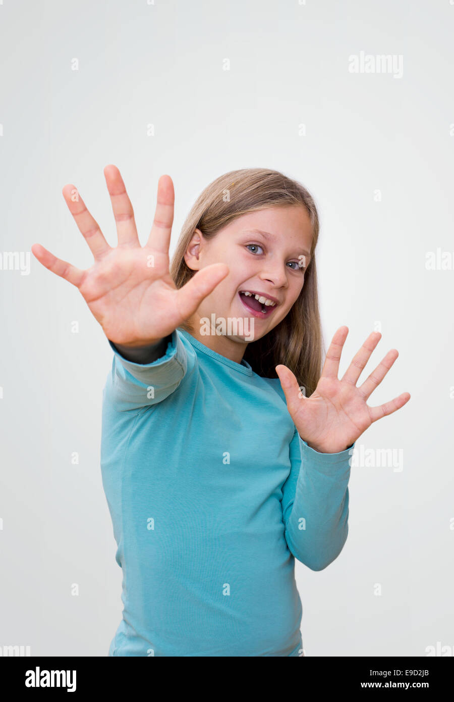 Petite fille aux longs cheveux montre ses dix doigts Banque D'Images