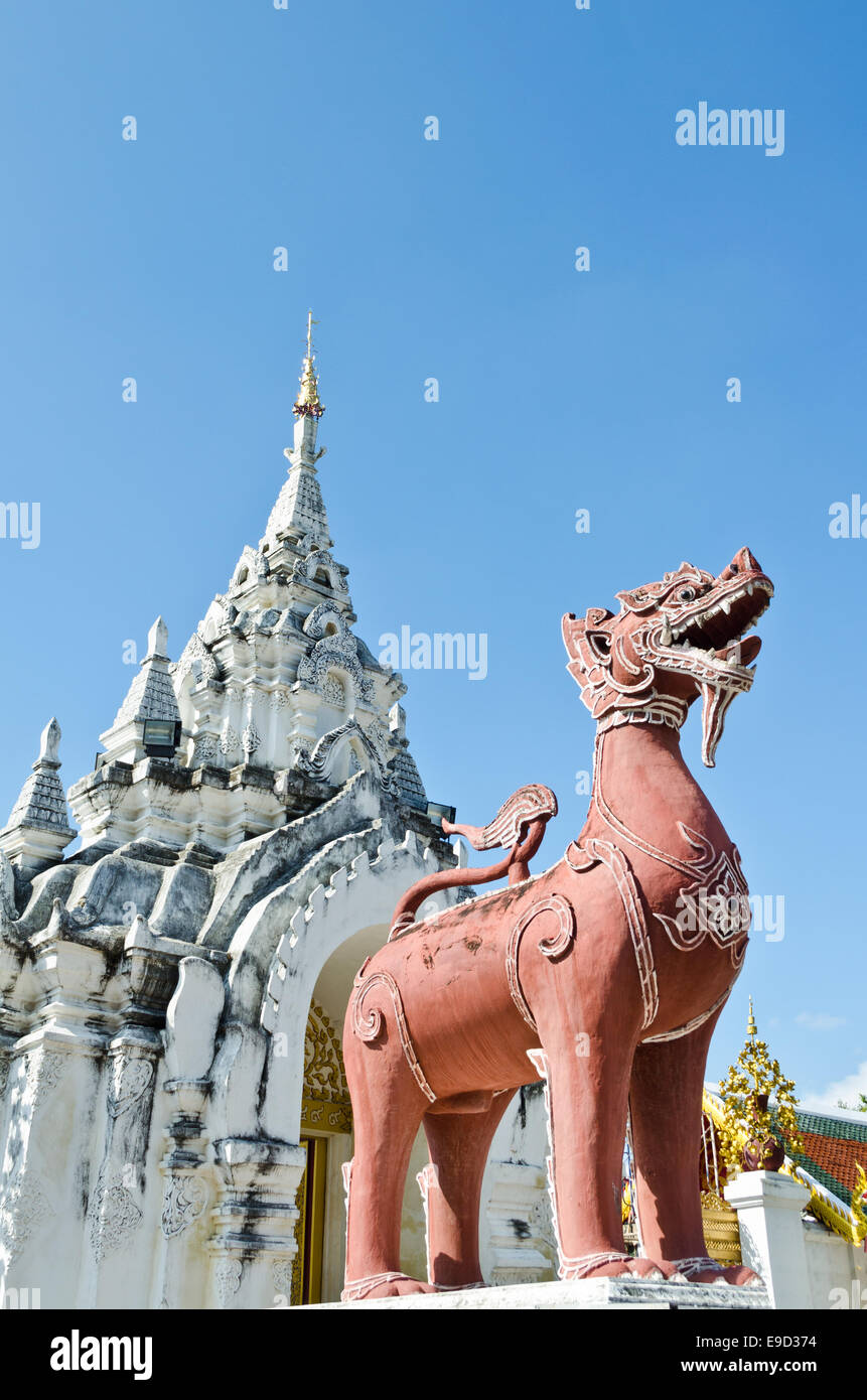 Statue de lion rouge à l'avant que le temple Wat Phra That Hariphunchai province de Lamphun en Thaïlande Banque D'Images