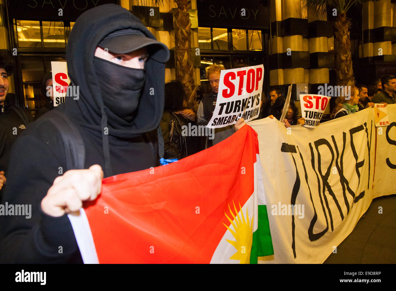 Londres, 25 octobre 2014. Des dizaines de la communauté kurde et leurs partisans ont manifesté devant l'exclusif Savoy comme l'ambassadeur de la Turquie a accueilli les invités à un bal. Les Kurdes accuser la Turquie d'aider dans l'élimination de ISIS Jihadistes de Kurdes, qui ont tenu une longue campagne pour un Etat kurde autonome. Sur la photo : Un manifestant masqué prend en charge une bannière à lire 'La Turquie ! Cesser de soutenir ISIS' Crédit : Paul Davey/Alamy Live News Banque D'Images