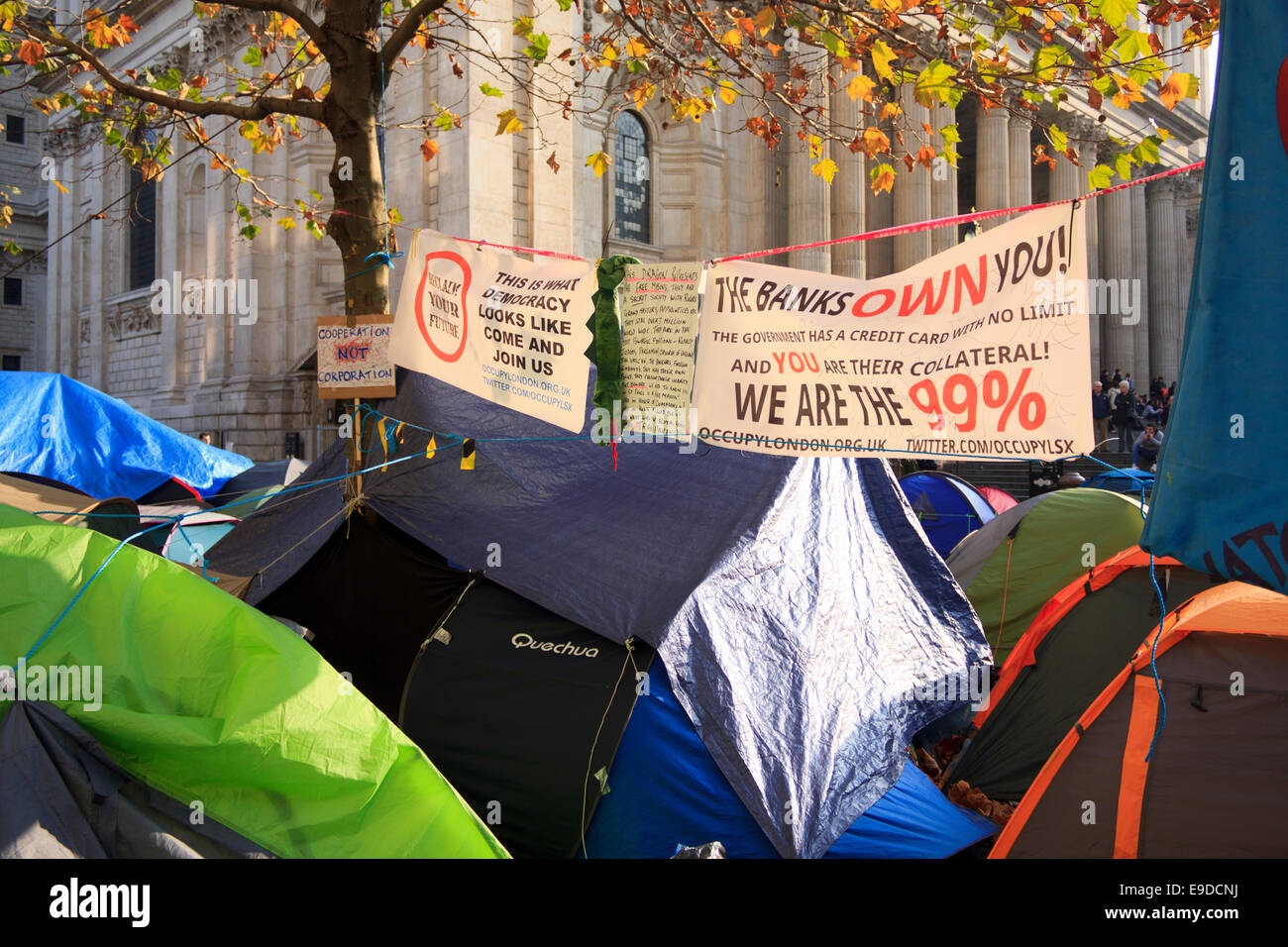 Les bannières affichées au-dessus des tentes le capitalisme par des manifestants Occupy London en face de la Cathédrale St Paul à Londres, au Royaume-Uni. Banque D'Images