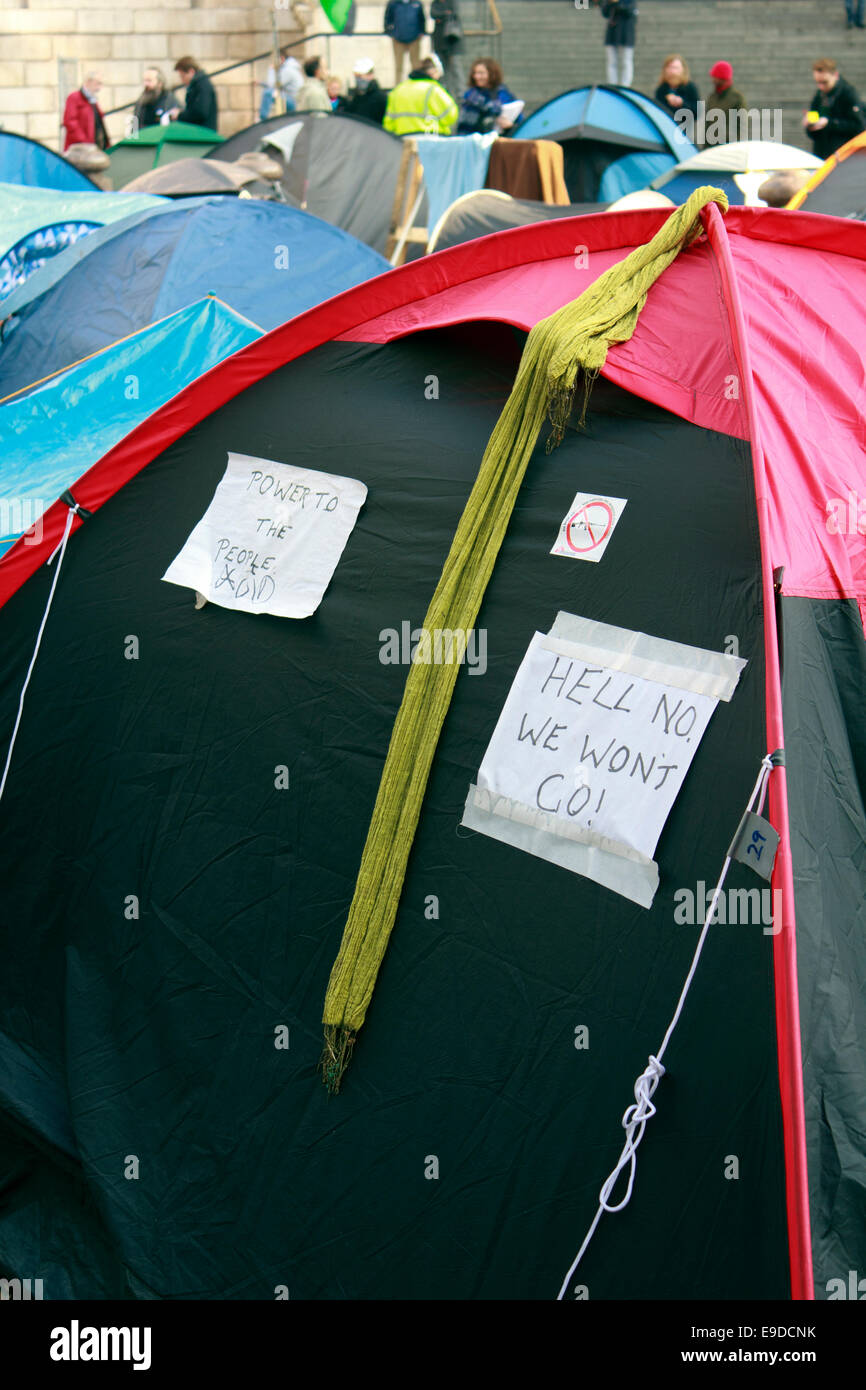 Le capitalisme anti affiches exposées parmi les tentes de camping par Occupy London manifestants en face de la Cathédrale St Paul, London, UK Banque D'Images