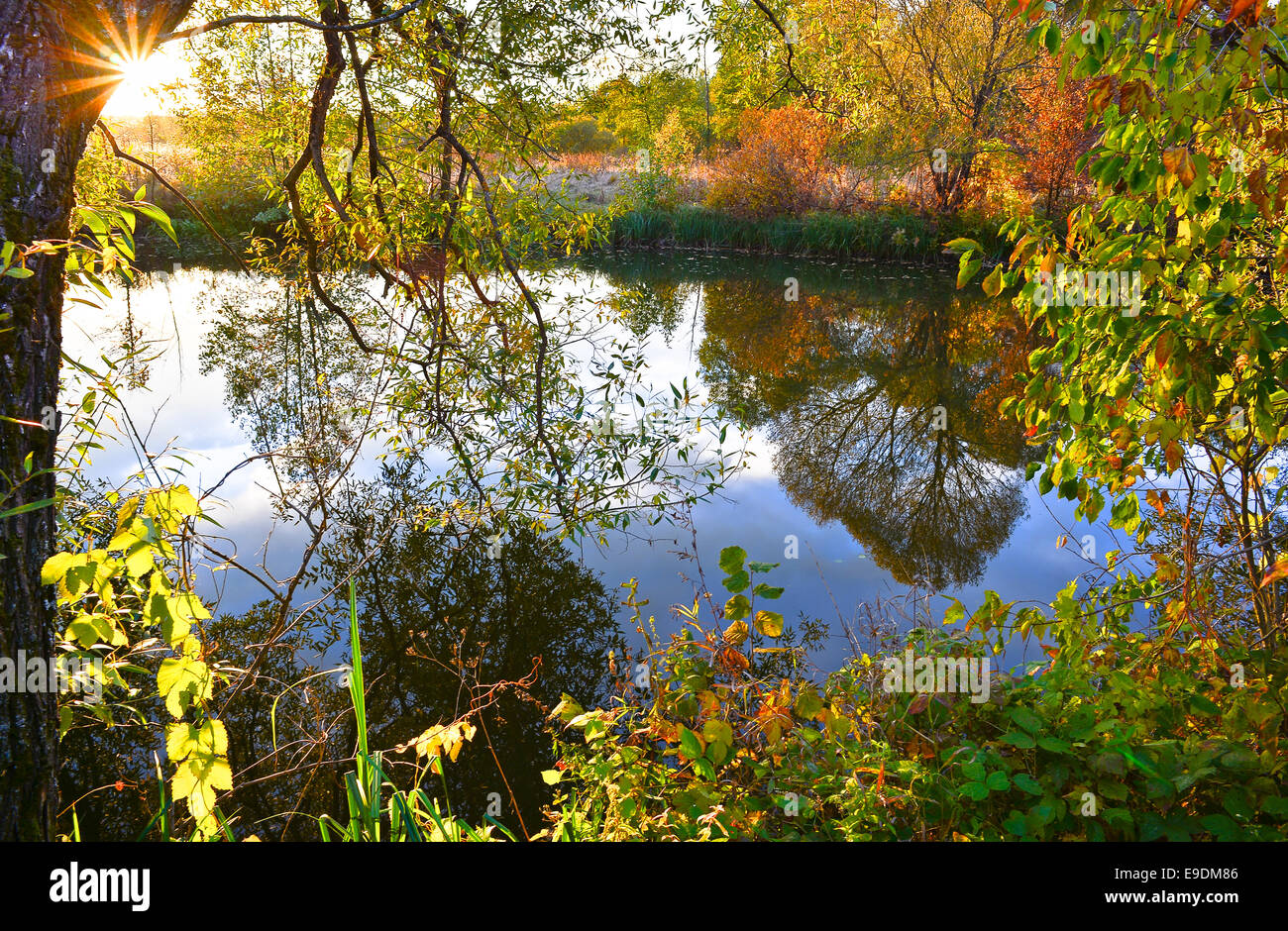 Coucher de soleil coloré d'automne sur la rivière avec les rayons du soleil Banque D'Images