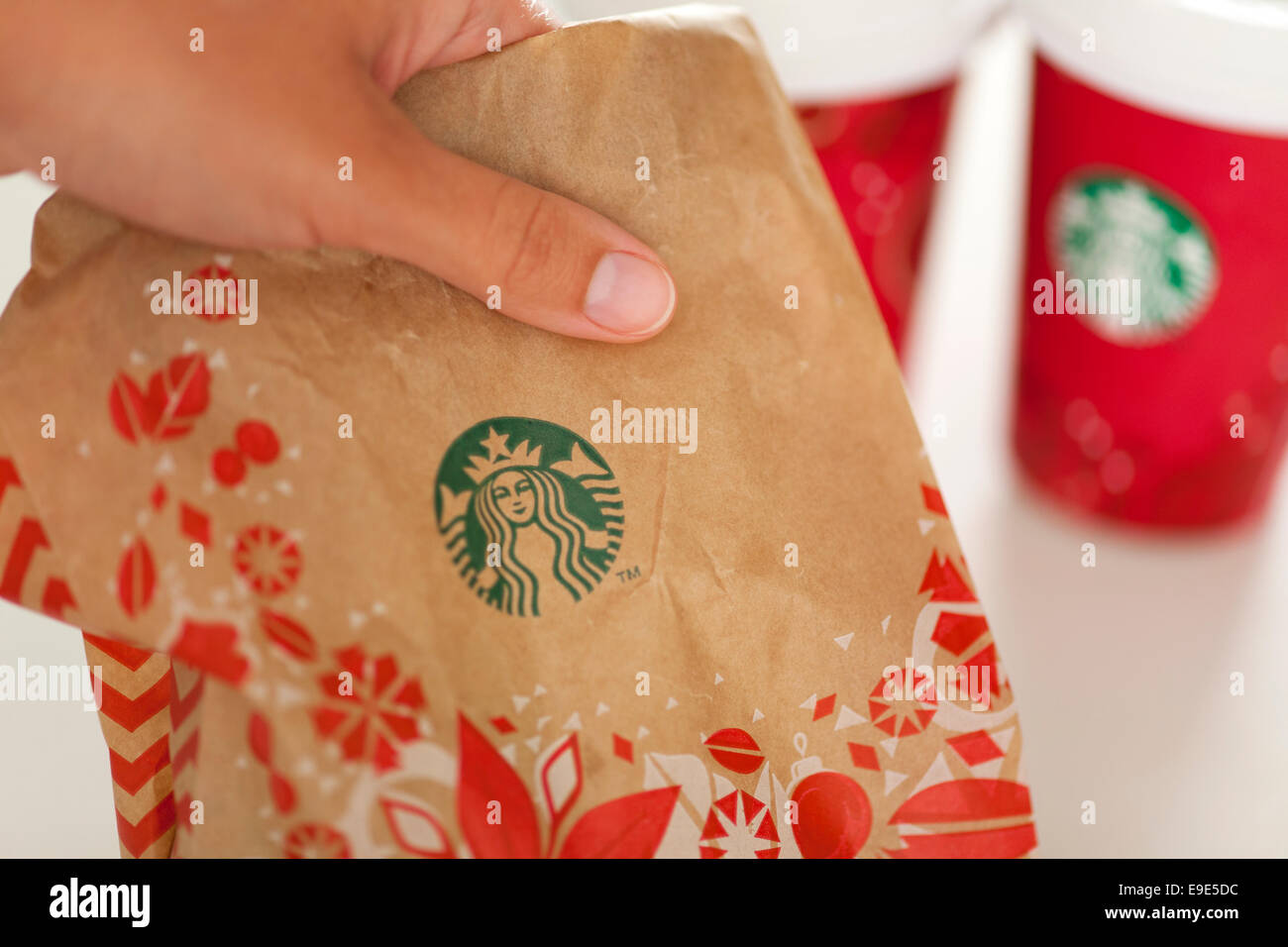 Un Starbucks à emporter main femme sac en papier Maison de vacances Maison de vacances avec deux tasses de papier de l'espresso sur arrière-plan. Banque D'Images