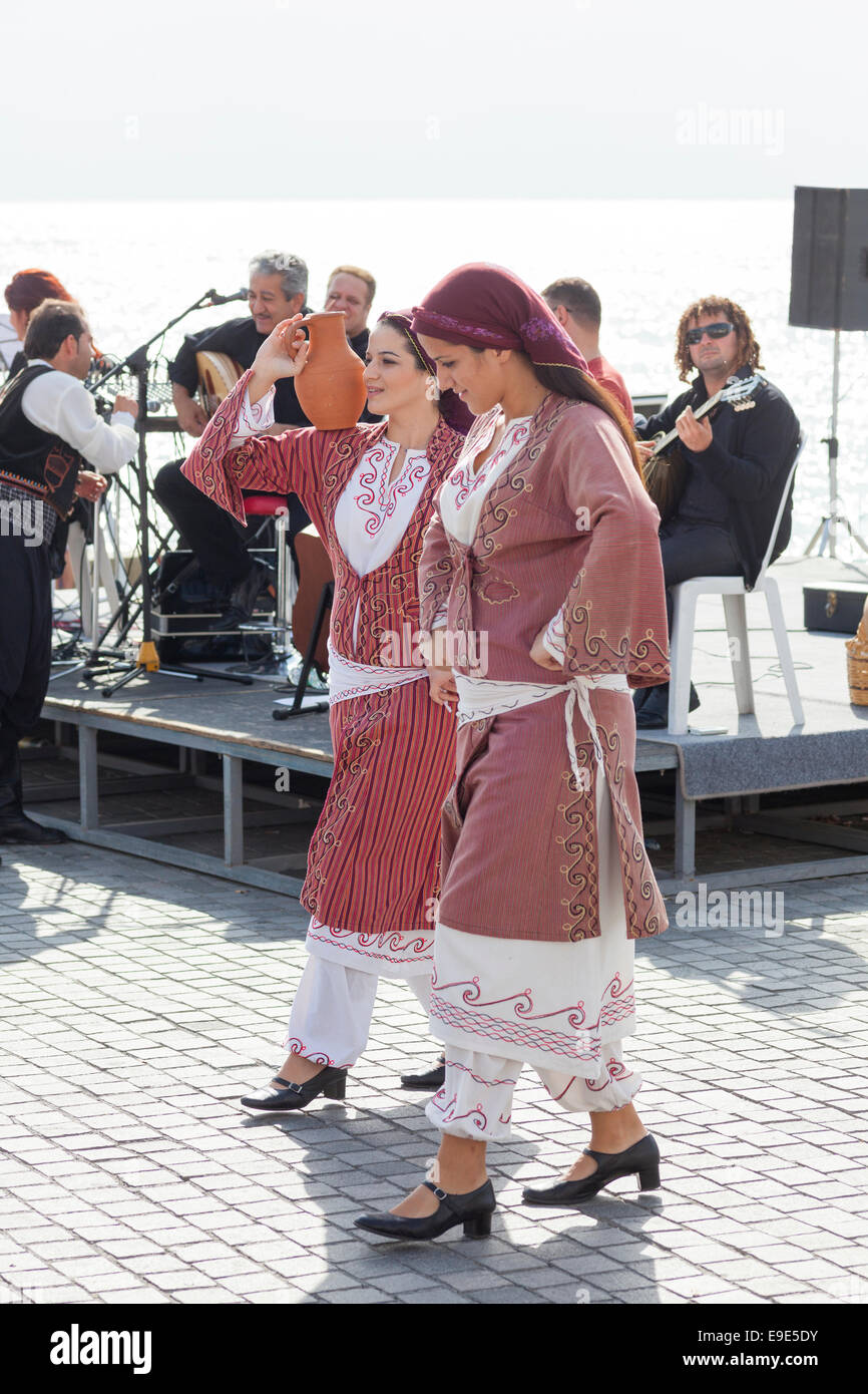 Paphos, Chypre - Novembre 24, 2013 Deux jeunes femmes en costumes traditionnels chypriotes danser au son des musiciens sur le front. Banque D'Images