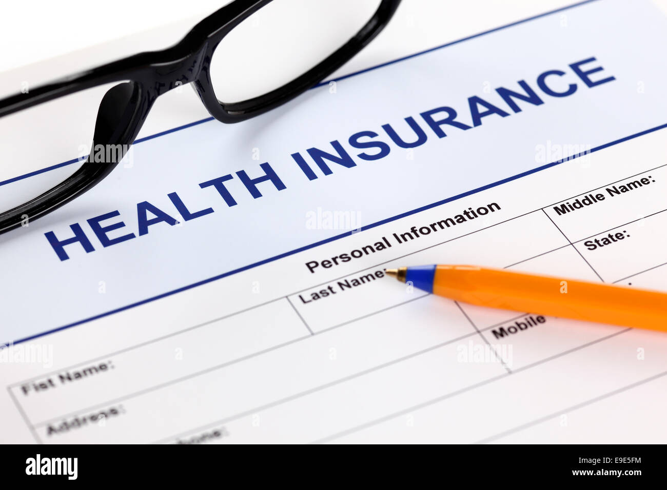 Formulaire d'assurance santé avec des lunettes et stylo à bille. Banque D'Images