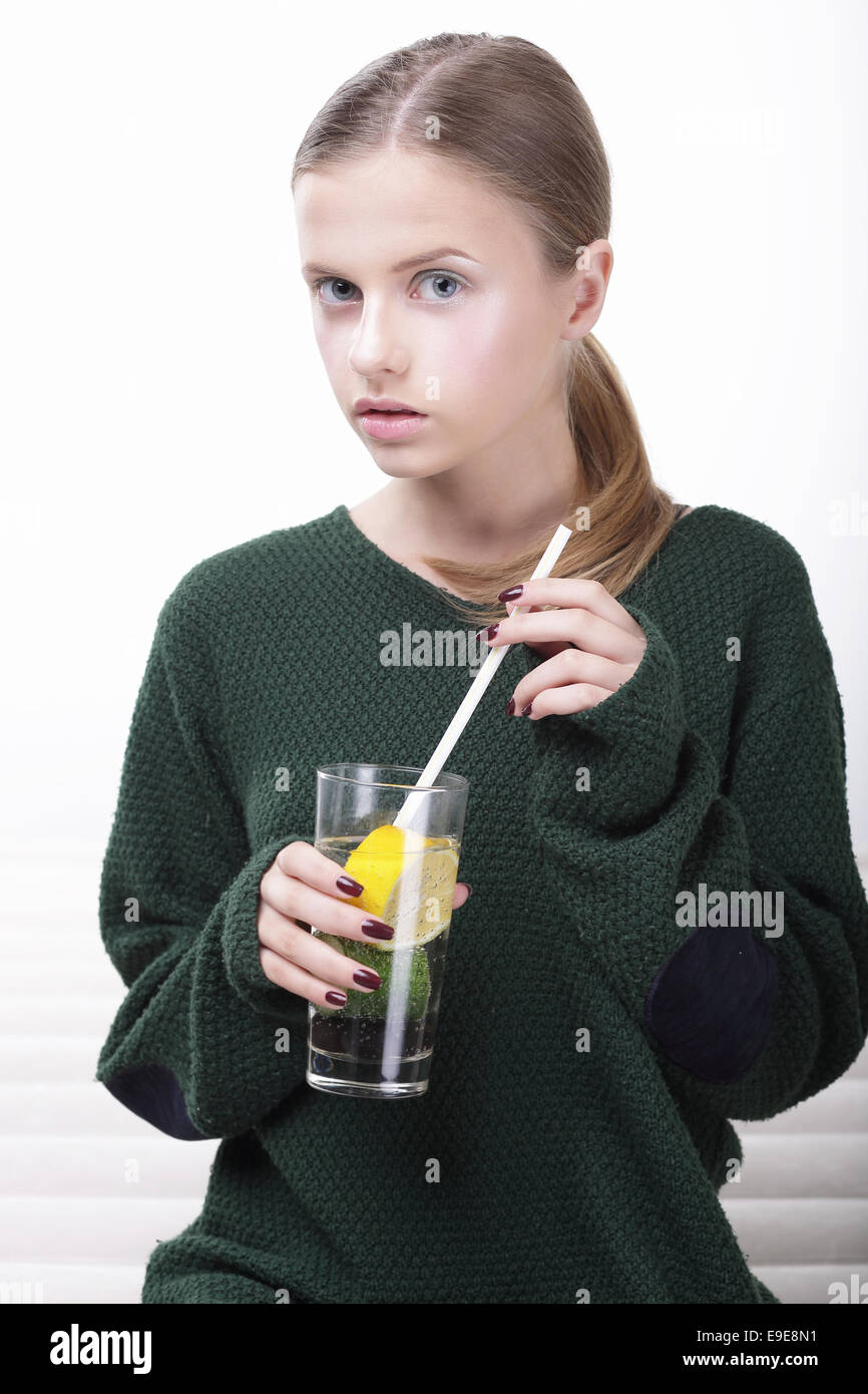 Jeune femme en maillot vert avec un verre de boisson gazeuse Banque D'Images
