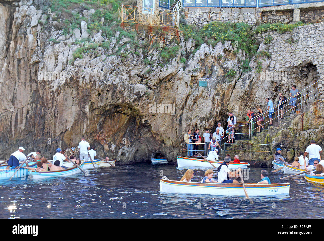 Les touristes en ligne et dans de petites embarcations attendent d'entrer dans la célèbre Grotte bleue sur l'île de Capri, Italie Banque D'Images