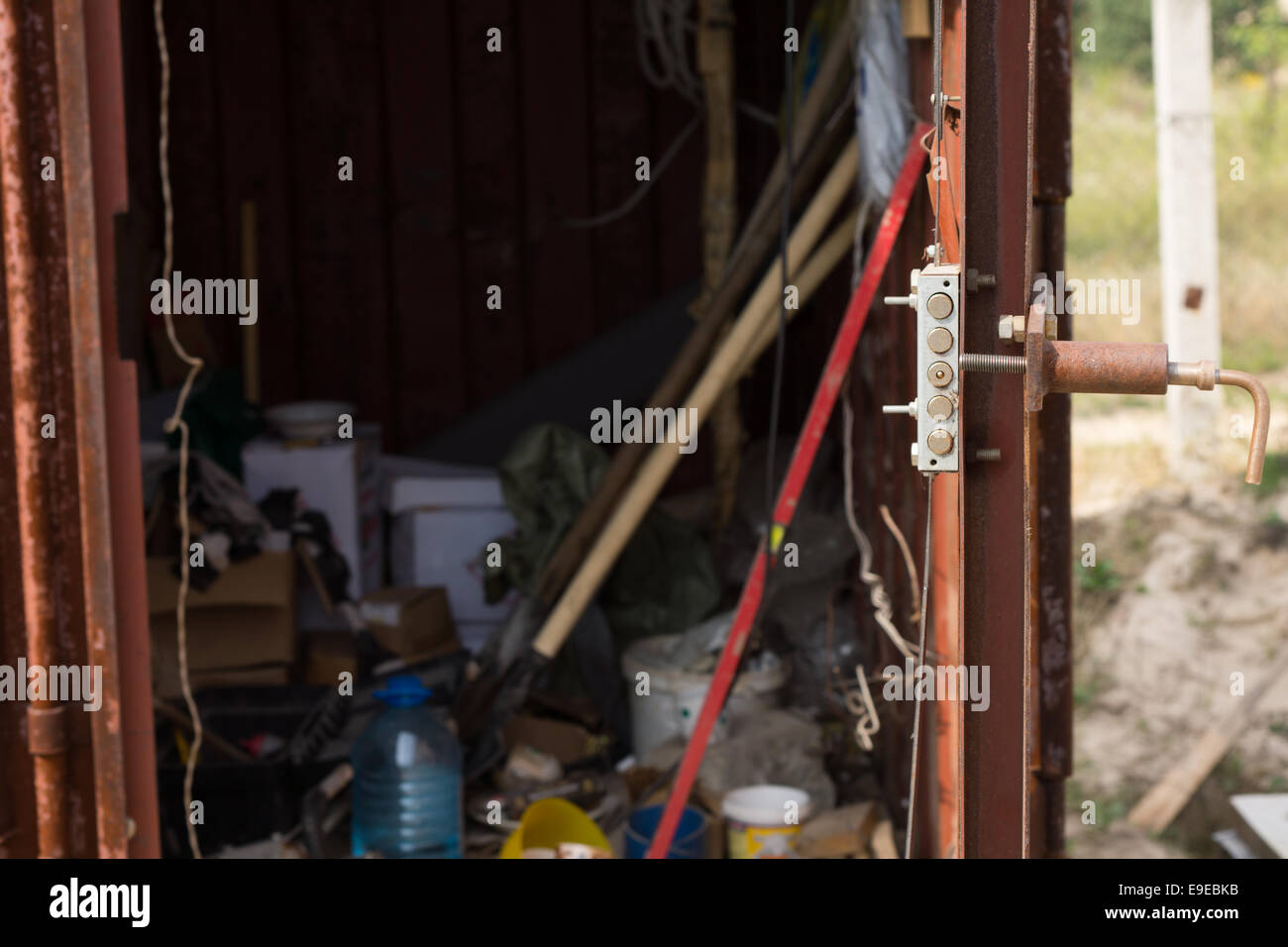 Voir à travers la porte ouverte dans un cabanon en bois sur un chantier rempli de divers équipements et fournitures Banque D'Images