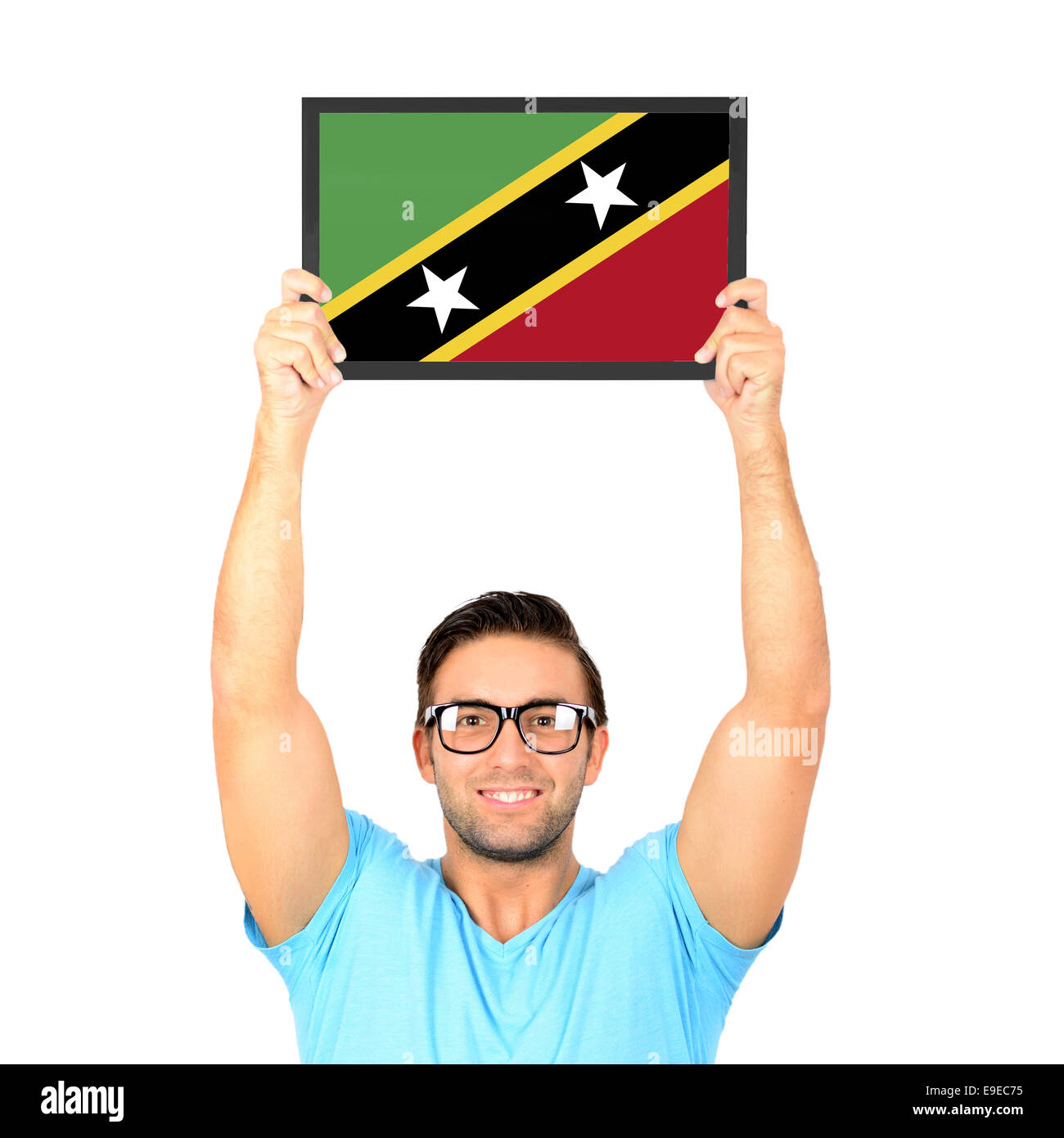 Portrait of a young man holding up conseil occasionnels avec drapeau national de St Kitts et Nevis Banque D'Images