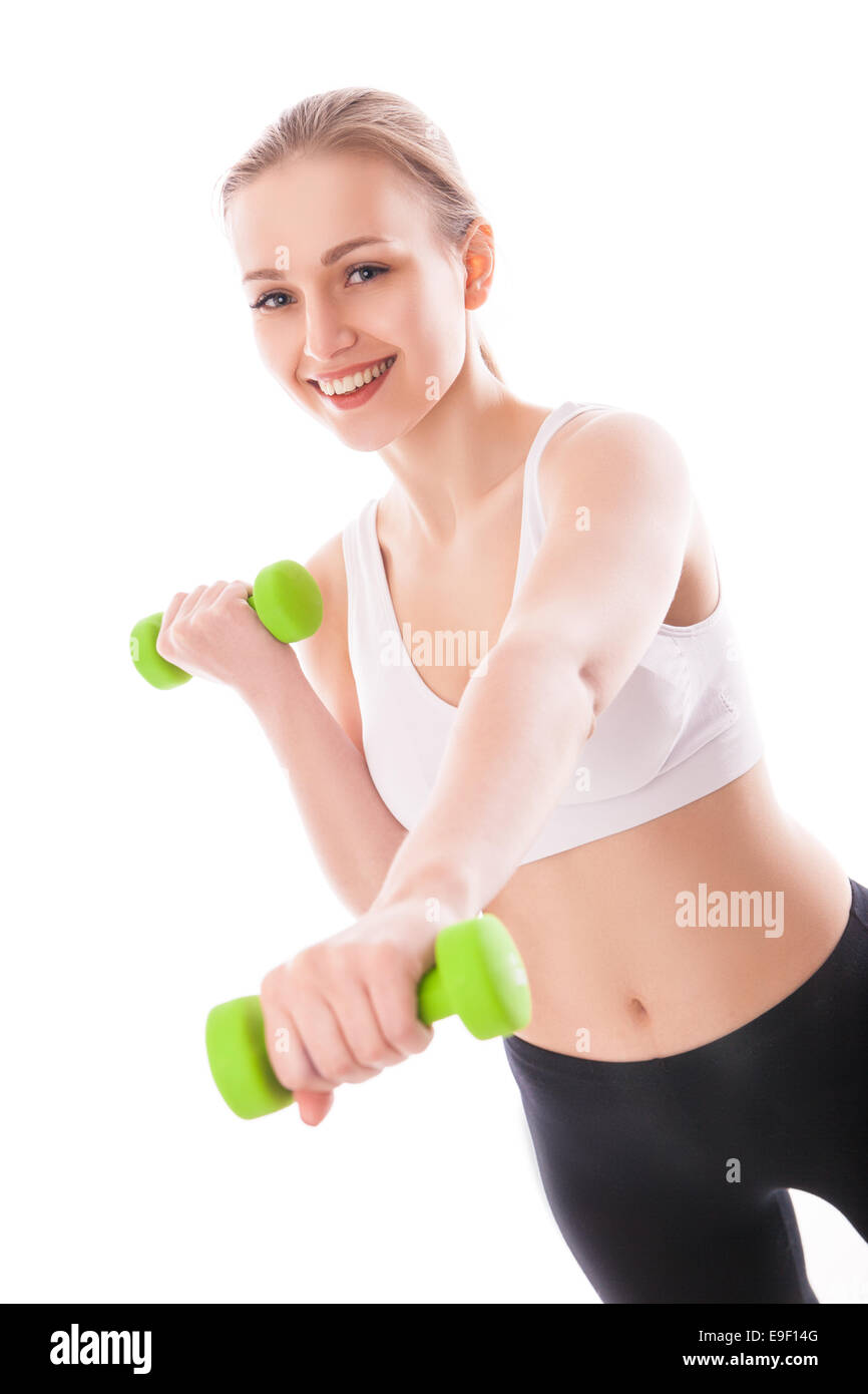 Smiling femme athlétique muscles jusqu'pompage avec haltères courtes sur fond blanc Banque D'Images