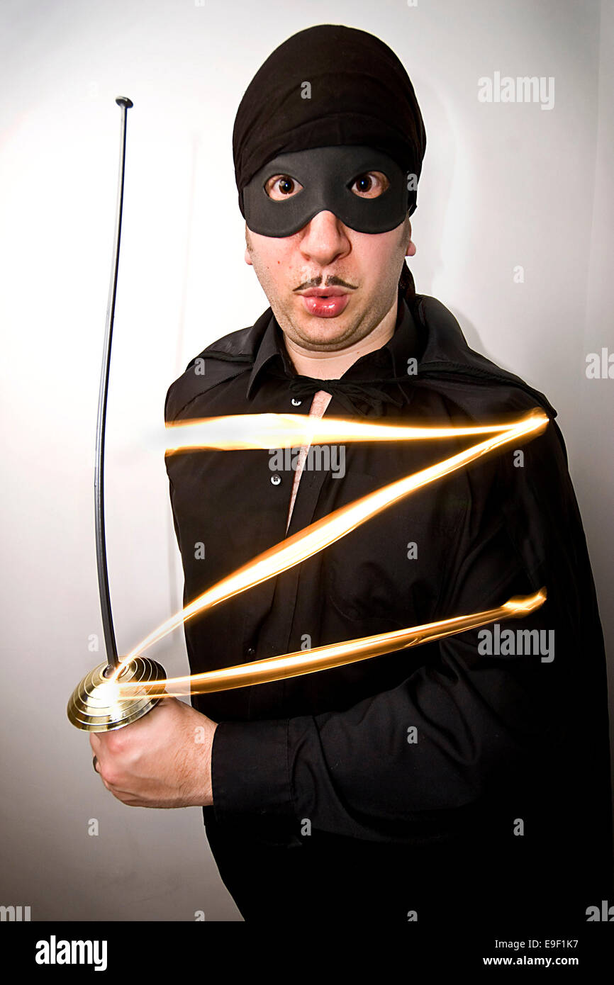 Un homme vêtu d'un drôle de masque de Zorro tenue, avec une épée, Banque D'Images
