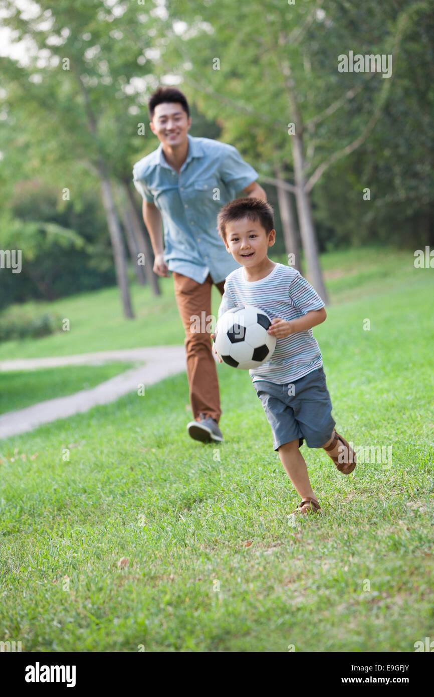 Heureux père et fils jouent au football Banque D'Images