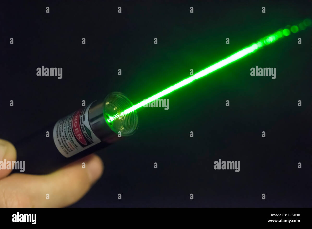 Faisceau laser vert lumineux venant d'un pointeur laser à main terminal Banque D'Images