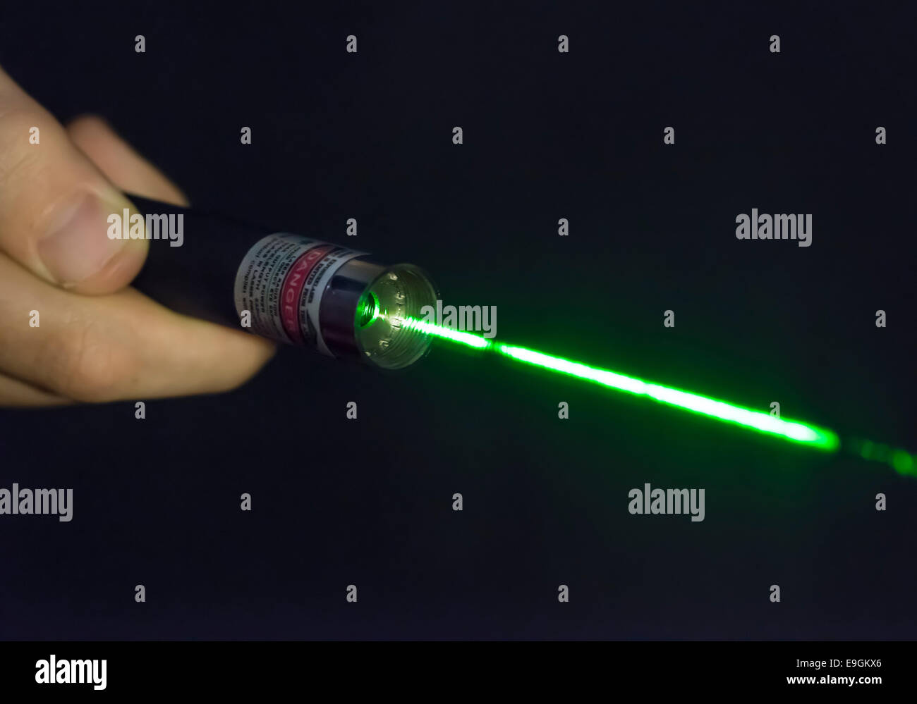 Faisceau laser vert lumineux venant d'un pointeur laser à main terminal Banque D'Images