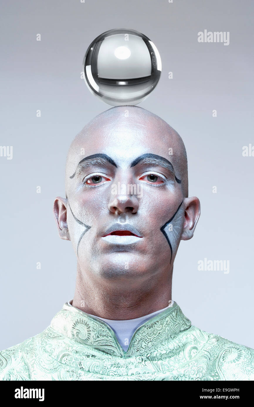 Portrait d'un magicien avec bille de verre dans du maquillage et costume Banque D'Images