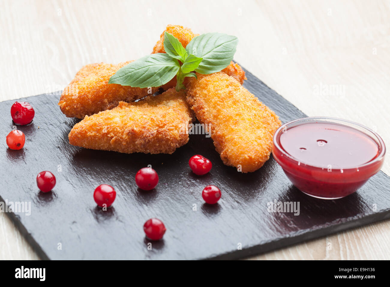 Bâtonnets de fromage frit servi avec sauce aux canneberges, sur pierre noire Banque D'Images