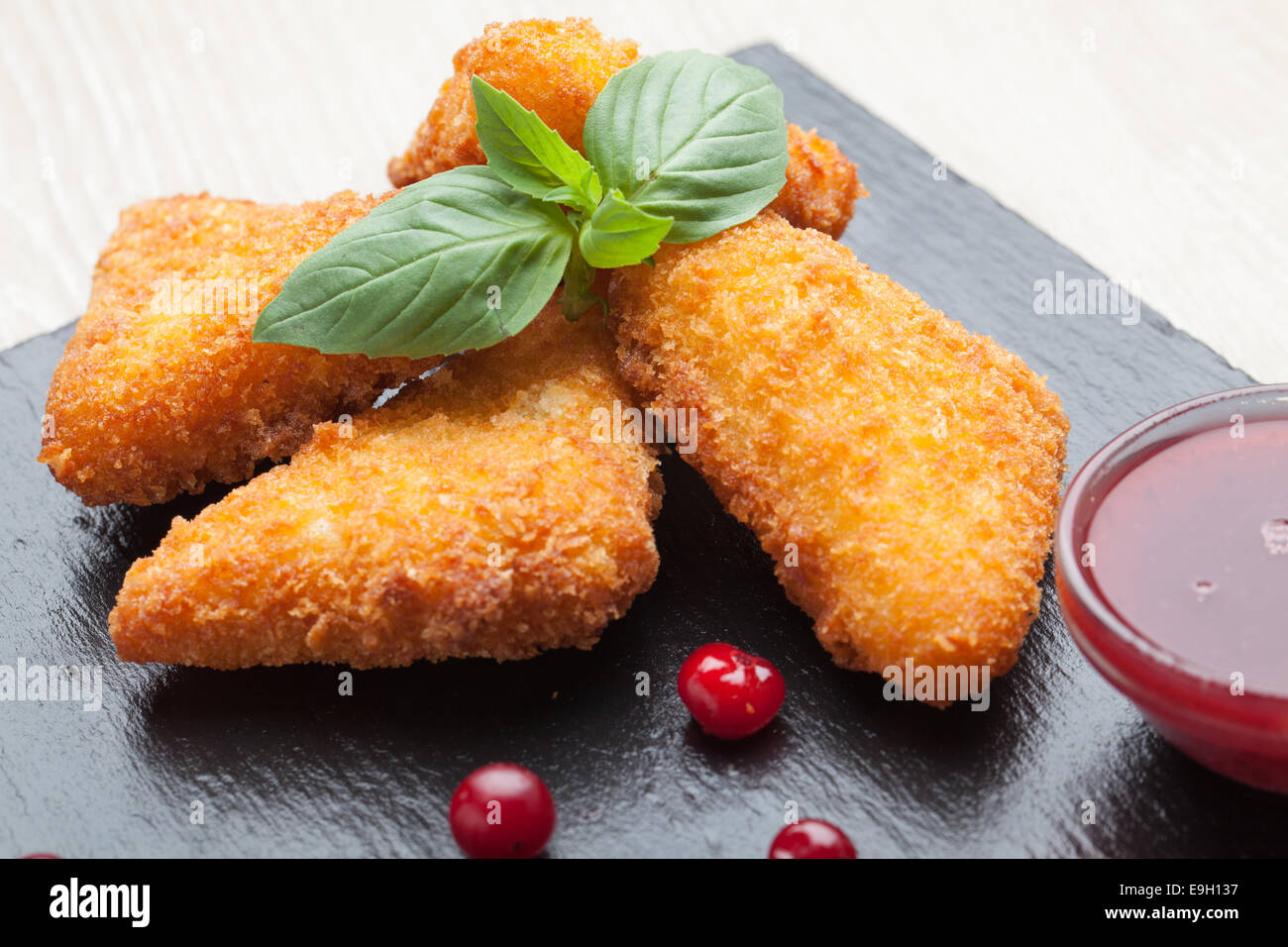 Bâtonnets de fromage frit servi avec sauce aux canneberges, sur pierre noire Banque D'Images