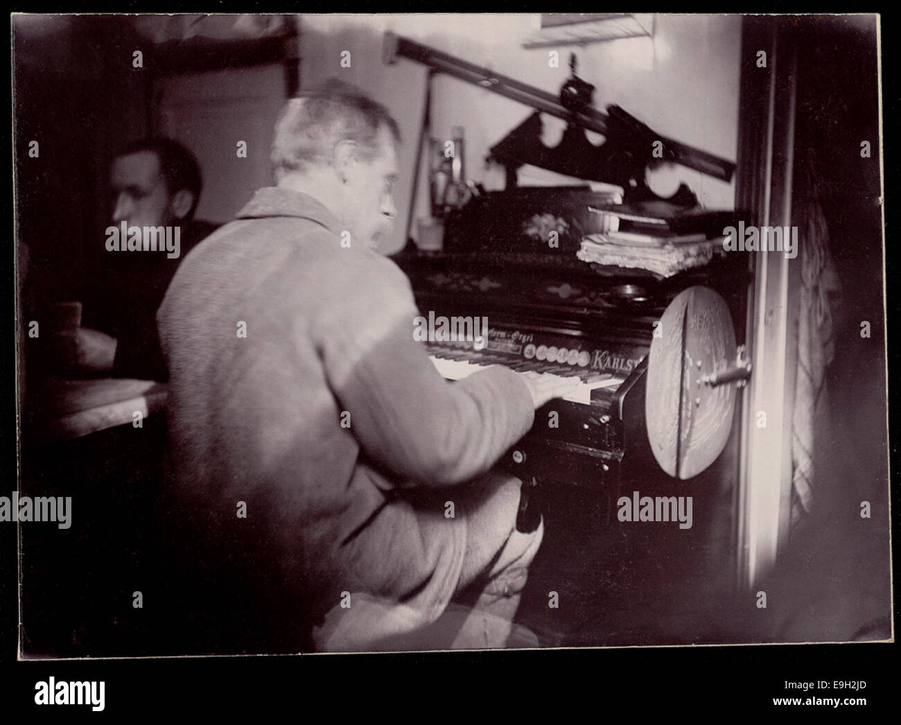 Un événement musical de divertissement à bord du navire 'Fram', avec une performance à l'orgue, dans le cadre des expéditions de Fridtjof Nansen. L'image est archivée à la Bibliothèque nationale de Norvège. Banque D'Images