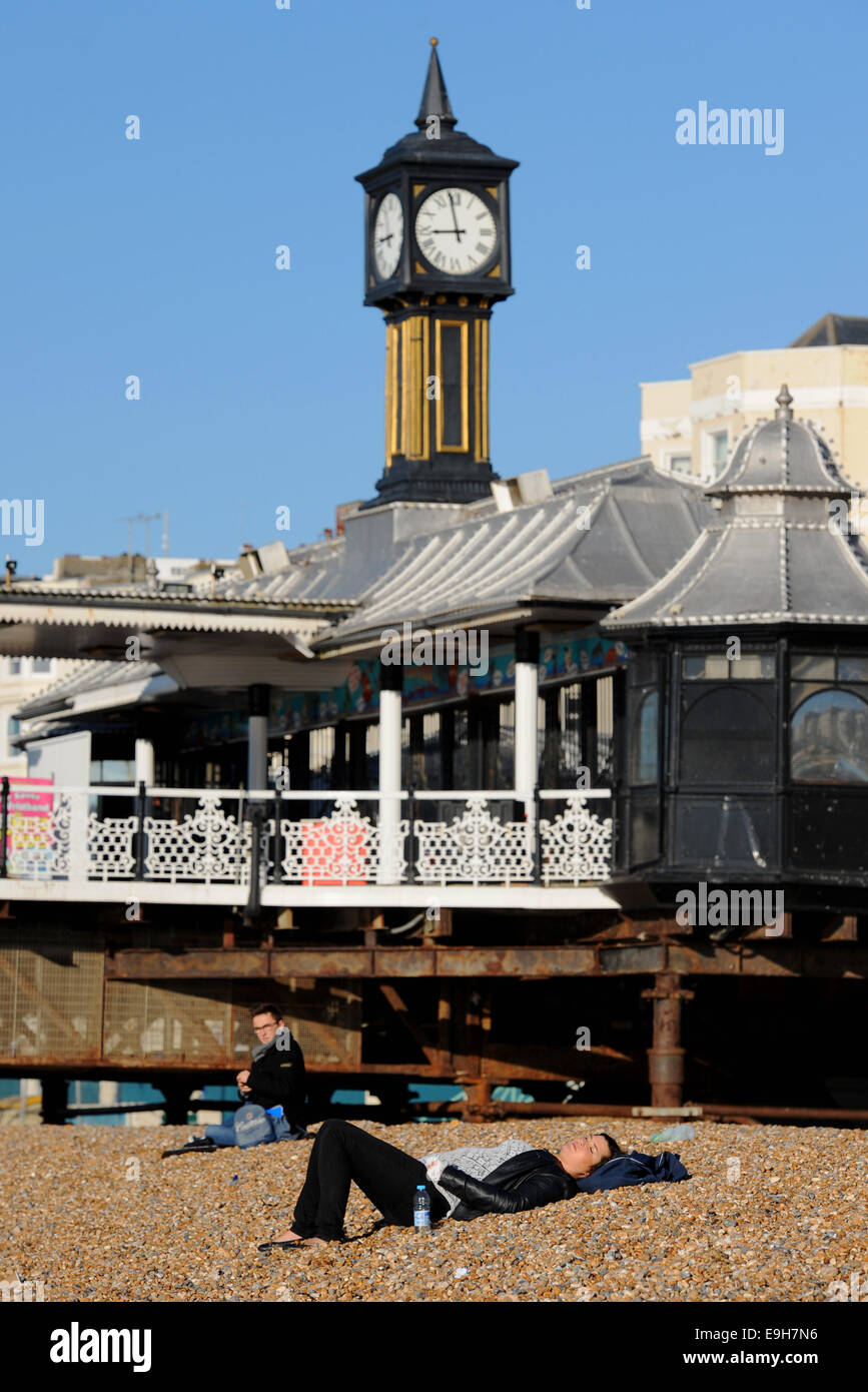 Brighton, UK. 28 octobre, 2014. Météo britannique. Les gens de profiter de la plage par le quai dans la mesure où ils font les la plupart des temps chaud et ensoleillé sur le front de mer de Brighton tôt ce matin . Crédit : Simon Dack/Alamy Live News Banque D'Images