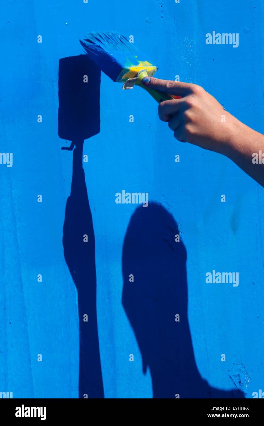 La main de l'homme mur Peinture avec pinceau. Banque D'Images