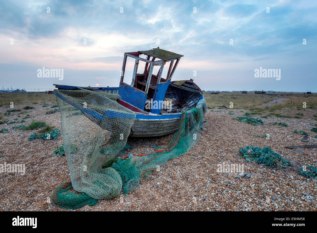 Un vieux bateau de pêche abandonnés avec des filets en hauteur sur une plage Banque D'Images