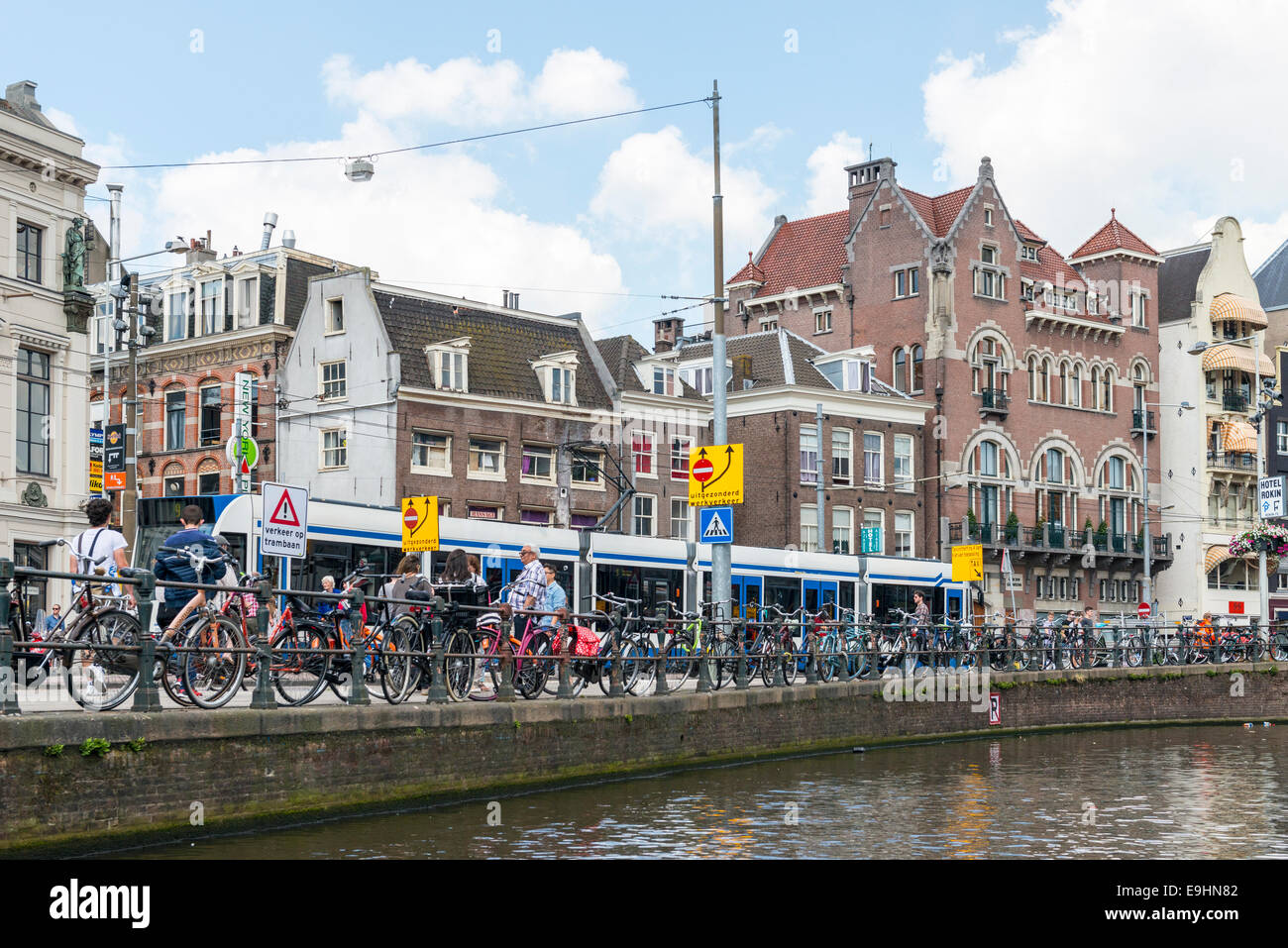 Les vélos verrouillé à la grille le long d'un canal dans la ville d'Amsterdam, Pays-Bas Banque D'Images