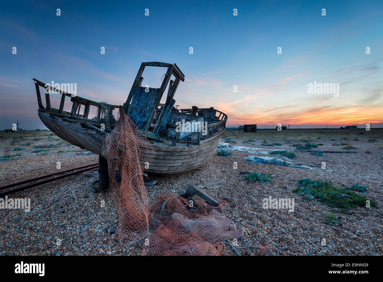 Une vieille épave bateau de pêche au crabe dormeur dans le Kent avec le nouveau phare dans l'extrême gauche distance Banque D'Images