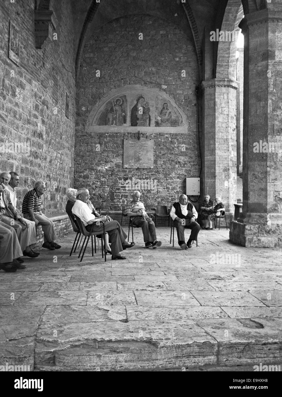 Les hommes plus âgés en relaxant dans le centre de San Gimignano, Toscane Banque D'Images