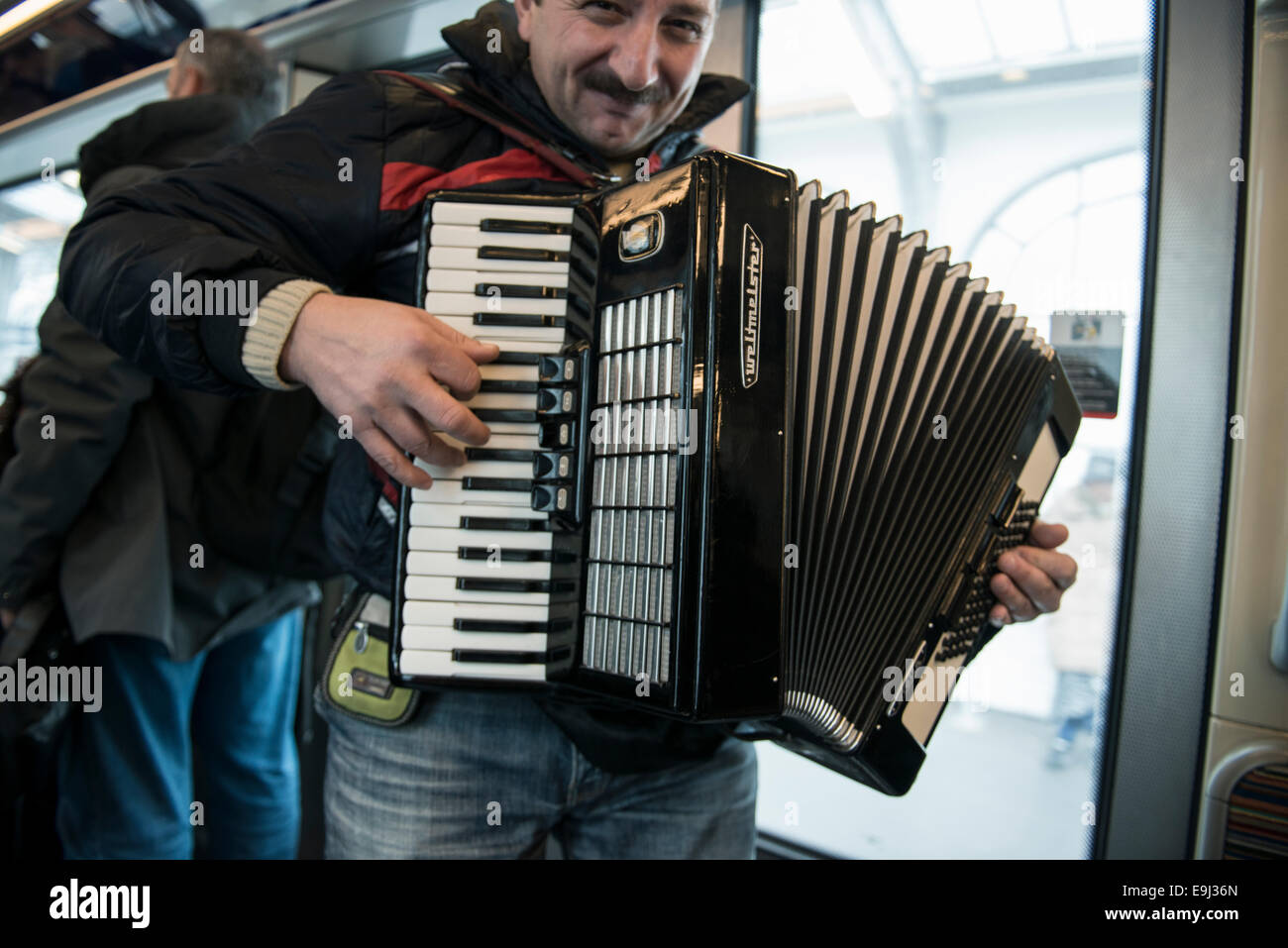 Un joueur d'accordéon busks sur le métro parisien trains avec un instrument à vent traditionnel Banque D'Images