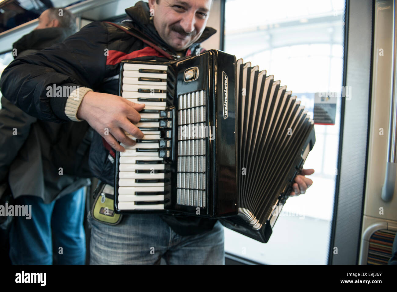 Un joueur d'accordéon busks sur le métro parisien trains avec un instrument à vent traditionnel Banque D'Images